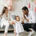 Guarda de filhos Happy family celebrating a child's birthday with balloons indoors.